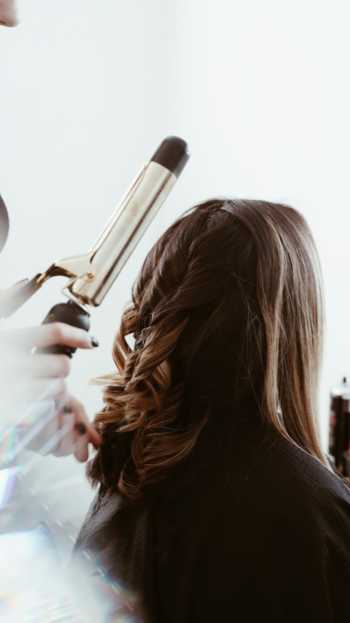 Stylistin bringt einer Kundin bei Studio Nine Locken in Form